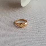 Anillo dorado con sello de estrella.