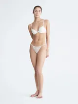 Colaless blanco con encaje elástico transparente y tiras delgadas.