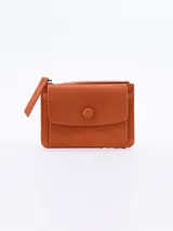 Billetera pequeña color naranja con textura símil piel de cocodrilo. Tiene un compartimento principal con cierre y un bolsillo frontal con solapa y broche a presión.