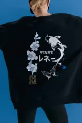 Buzo oversize de cuello alto confeccionado en frisa, con hombros caídos y bolsillos delanteros. Presenta una estampa artística en la espalda con motivos orientales, incluyendo un pez koi, flores y una mariposa.