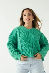 Sweater verde esmeralda de punto con diseño trenzado y textura en relieve, fit amplio y cómodo, con hombros caídos y cuello redondo.