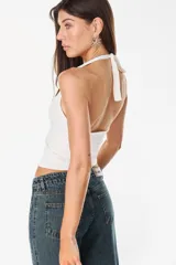 Top negro de cuello halter, confeccionado en mezcla de poliéster y spandex, de diseño ajustado al cuerpo y estilo minimalista.