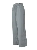Pantalón de corte amplio y tiro alto, confeccionado en una mezcla de lino orgánico y viscosa. Presenta cintura elástica con cordón ajustable y detalles de encaje broderie tono sobre tono en los laterales y en el ruedo.