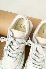 Championes de cuero sintético color beige con detalles plateados.