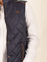 Chaleco beige capitoneado con cierre frontal y cuello alto.