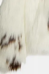 Chaqueta de pelo sintético con estampado animal tipo vaca, cuello solapa, manga larga y forro interior.