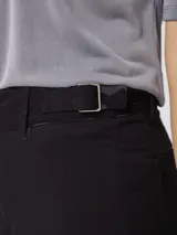Pantalón de corte recto y pierna ancha, color beige, con cintura de tiro medio y cierre frontal.
