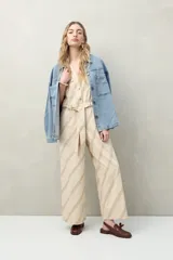 Mono enterito de algodón con rayas verticales color verde claro y beige, con cuello en V, sin mangas, con cierre frontal con botones y cinturón de lazo.