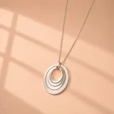 Collar de plata 925 con cadena fina y dije colgante compuesto por cuatro aros concéntricos ovalados.