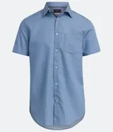 Camisa azul de manga corta con cuello clásico, corte slim fit, cierre frontal con botones blancos y bolsillo de parche en el pecho.