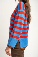 Sweater de punto con diseño de rayas horizontales en azul y rojo, cuello redondo y puños con terminación en color marrón.