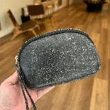 Mini sobre de cuero negro con textura desgastada y cierre plateado.