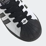 Championes Adidas Superstar II, blancos con detalles en negro, incluyendo las tres tiras laterales y la puntera de goma. Cordones negros y suela negra.