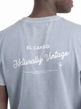 Camiseta celeste de manga corta con cuello redondo y estampado en la espalda con el logo de la marca y la frase "Naturally Vintage".