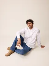 Camisa de manga larga en color blanco, confeccionada en algodón. Presenta cuello abotonado, cierre frontal con botones y un bolsillo en el pecho.