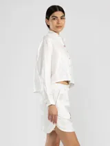 Short de lino italiano color blanco con hilo metalizado, de corte relajado y talle medio.