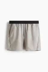 Short deportivo de tejido funcional con tecnología DryMove para absorción de sudor. Presenta cintura elástica con cordón oculto, bolsillos laterales al bies, aberturas en el bajo y detalles reflectantes.