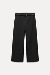 Pantalón culotte negro de tiro medio con trabillas y cinturón fino efecto piel con hebilla metálica. Presenta raya planchada y cierre de cremallera oculta en la costura.