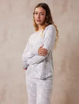 Conjunto de pijama estampado marca René Rofé, compuesto por pantalón largo y remera de mangas largas con puños. El pantalón tiene cintura elastizada con lazo de ajuste.