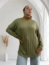 Polera verde oliva de tejido trenzado con cuello alto y puños de cuero marrón.