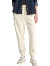 Jogger de corte regular color beige, con cintura elástica con cordón ajustable y puños elásticos en los tobillos. Presenta un pequeño logo bordado en la parte superior.