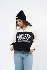 Buzo de estilo deportivo con diseño de bloques de color en blanco y bordó. Presenta cuello alto con medio cierre frontal, mangas largas con puños acanalados y estampado gráfico frontal con la palabra Society.