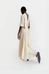 Vestido largo color crema, de corte holgado, con escote en V y mangas 3/4. Incluye un chaleco largo a juego.