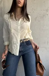 Camisa color manteca con bordado tipo broderie en el frente y mangas 3/4.