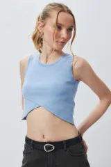 Musculosa corta negra sin mangas, de corte asimétrico frontal y ceñida al cuerpo.