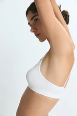 Top deportivo de diseño minimalista, sin costuras, con escote en V y breteles finos. Confeccionado en tejido elástico de tacto suave.