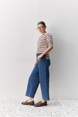 Jean de corte barrel, tiro alto, con silueta amplia que se estrecha hacia el tobillo. Confeccionado en denim azul oscuro con costuras a contratono.