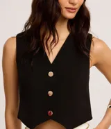 Chaleco slim color marrón, confeccionado en crepé, con escote en V y abotonado frontal.