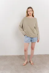 Remera color arena de corte holgado y mangas largas.