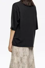 Falda midi de tejido liviano con estampado de piel de serpiente en tonos beige y gris. Diseño con capas superpuestas y bajo asimétrico con volados.