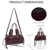 Bolso tipo barrel o doctor bag de cuero charol color vino tinto. Presenta dos asas superiores con detalle de trenzado y ojales metálicos, y múltiples tiras largas de cuero colgando de los herrajes circulares frontales. Incluye correa ajustable para llevar al hombro.