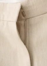 Pantalón de vestir de tiro medio, corte recto y largo, confeccionado en mezcla de lino y viscosa. Cuenta con trabillas en la cintura, dos bolsillos laterales y cierre frontal con gancho y cremallera.