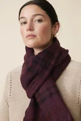 Bufanda tejida a cuadros en color borgoña, con flecos cortos en los extremos.