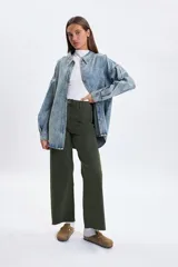 Pantalon de jean de corte ancho y tiro medio, en color verde oliva, con cierre frontal y bolsillos laterales.