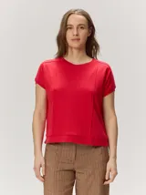 Remera negra de punto fino, con mangas cortas, cuello redondo y corte relajado. Cuenta con costuras verticales decorativas en el frente.