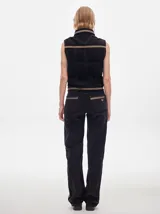 Pantalón de tiro medio confeccionado en pana negra, de corte holgado y diseño recto, con detalle de línea lateral en tono contrastante.