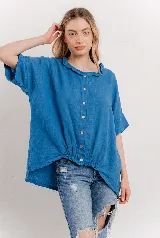 Blusa azul de lino con cuello fruncido, mangas cortas relajadas y base elastizada.