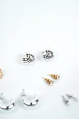 Set de aros variados que incluye pares de argollas plateadas de distintos tamaños, aros abridores con circón y perlas, y aros dorados de diseño geométrico.