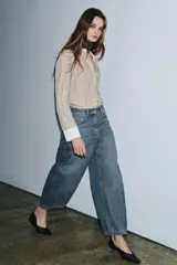 Jeans de tiro medio con corte balloon leg y largo al tobillo. Presenta diseño de cinco bolsillos, cintura con trabillas y cierre frontal con cremallera y botón metálico.