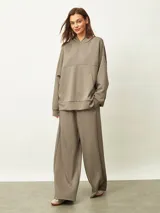 Buzo con capucha de corte oversize, color marrón topo, con bolsillo frontal tipo canguro y puños ajustados.