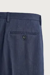Pantalón de traje de corte regular fit en color azul marino, confeccionado en una mezcla de lino y lana. Cuenta con bolsillos delanteros, bolsillos traseros de doble vivo con botón y raya marcada en el centro de las piernas.