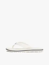 Ojotas blancas con tiras de tejido trenzado y una pequeña insignia con el monograma TH a contraste en la tira del dedo. La suela es de EVA con una línea decorativa azul marino en el borde.