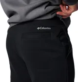 Pantalón tipo jogger de color negro, confeccionado en una mezcla de algodón, con cintura elástica ajustable mediante cordón interior, bolsillos laterales y traseros, y puños elásticos en los tobillos.
