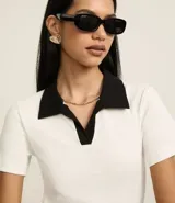 Blusa acanalada color borgoña con cuello polo contrastante en color crema, de mangas cortas y corte ajustado.