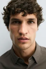 Camisa negra de corte slim fit, con cuello italiano y manga larga con puño abotonado. Cierre frontal de botonadura.