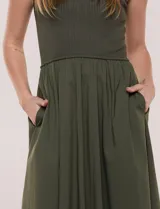Vestido midi sin mangas de color verde militar, confeccionado con la parte superior en tejido de punto acanalado con cuello alto y falda acampanada de gran vuelo.
